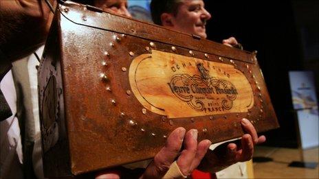Auctioneers hold up a specially-made box for a bottle of Veuve Clicquot in Mariehamn