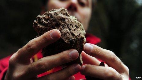 Man shows a volcanic stone from Chile's Puyehue volcano at Cardinal Samore Pass on the border between Chile and Argentina, near Osorno in southern Chile, on 6 June, 2011