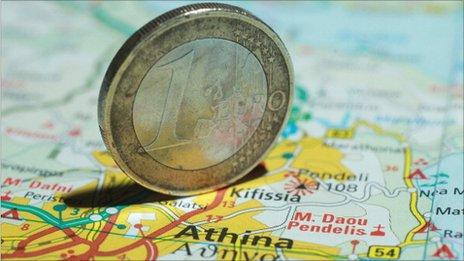 A euro coin on a map of Greece