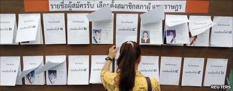 A woman checks a list before casting her ballot at a polling station in Bangkok, June 26, 2011