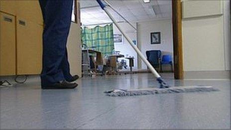 A hospital cleaner mopping a floor