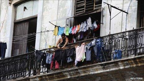 A woman hangs her laundry from the balcony of her colonial-era apartment in Havana 3 July, 2011