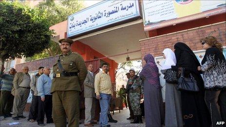 Egyptians queue outside a school turned into a polling station in Mansura, north of Cairo, 19 March 2011