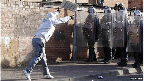 A Nationalist youth throws masonry at police in the Ardoyne area