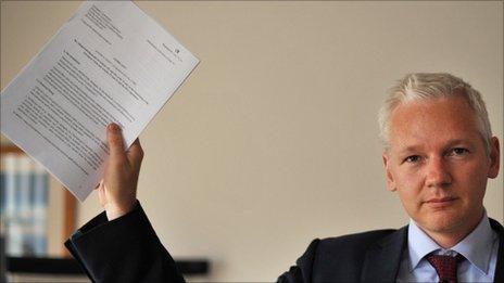 Julian Assange holding a document
