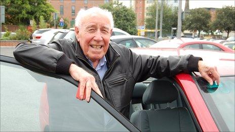 Geoffrey Williams, 87, standing next to his car