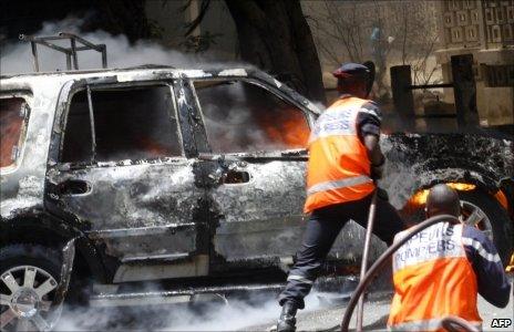 Rescue workers try to extinguish a car set on fire in Dakar (June)