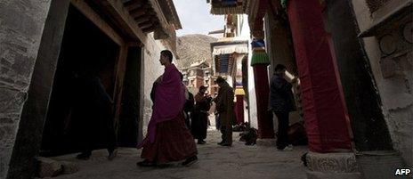 Tibetan monk walks past pilgrims at the Labrang monastery in Xiahe, Gansu province, file image