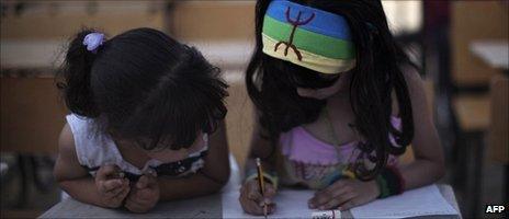 A Libyan girl from the Amazigh community wears a headband sporting the traditional symbol of peace as she attends a class in her ancient language of Tamazight in Jadu in eastern Libya in July 2011