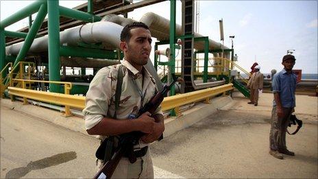 An anti-Gaddafi fighter stands guard at the Mellitah Oil and Gas complex