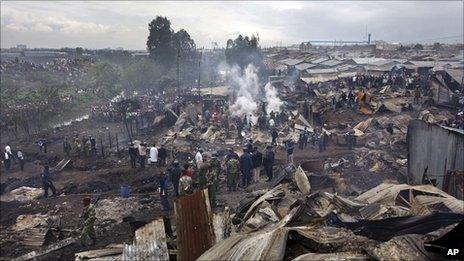 People pick through smouldering rubble in Sinai slum, Nairobi, Kenya (12 Sept 2011)