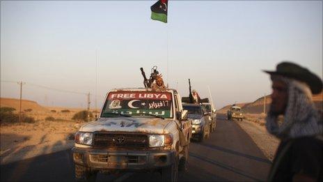 Former rebel fighters celebrate as they pass by a checkpoint near Bani-Walid, Libya, 12 Sept 2011.