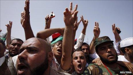 People flash victory signs as they gather at Martyrs Square after Friday prayers in Tripoli September 2