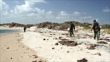 Armed police patrol a stretch of beach near Kiwayu Safari village