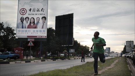 A man runs past a Bank of China billboard in Lusaka, the capital of Zambia