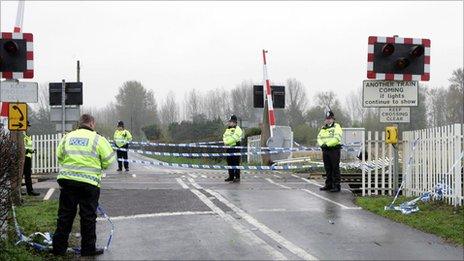 Policemen stand on the level crossing near the scene of a train crash in Ufton Nervet, Berkshire on 7 November 2004