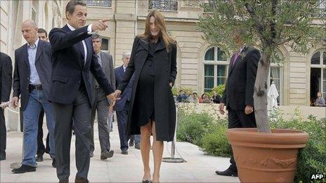 French President Nicolas Sarkozy and his wife Carla Bruni-Sarkozy walk in the gardens of the Elysee Palace in Paris, September 17, 2011