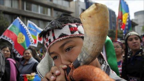 An indigenous Mapuche boy blows a horn during a protest in the Chilean capital, Santiago