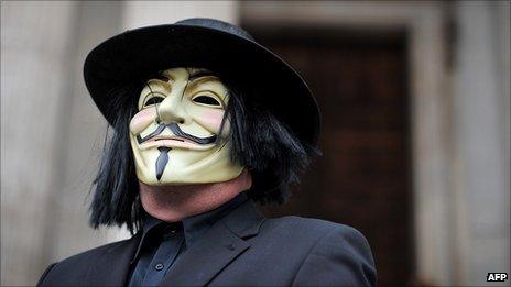 A masked protestor stands on the steps of St Paul's Cathedral in London