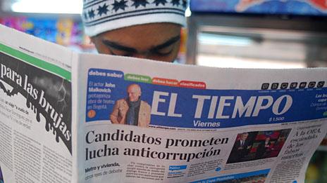 Man reading copy of El Teimpo newspaper with headline: Candidates promise anticorruption fight