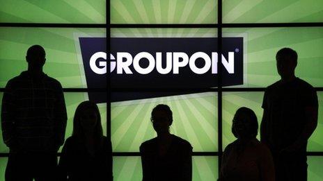 Groupon staff in front of logo