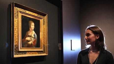 Curatorial assistant Francesca Sidhu, poses besides a painting by Leonardo da Vinci at the National Gallery