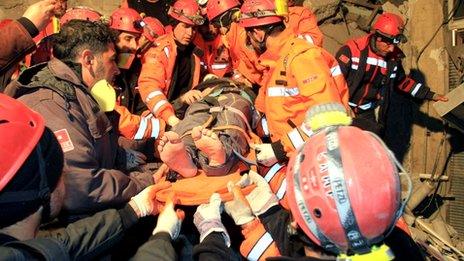 Rescuers carry a survivor from a collapsed building after an earthquake in Van, eastern of Turkey, on 9 November 2011