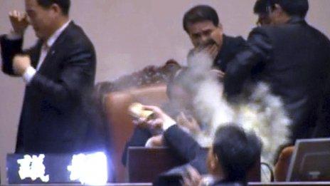 An opposition lawmaker detonates a tear gas canister in parliament as the free trade deal is passed