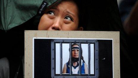 A protester holds a placard showing Gloria Arroyo behind bars outside the Supreme Court on 22 November 2011
