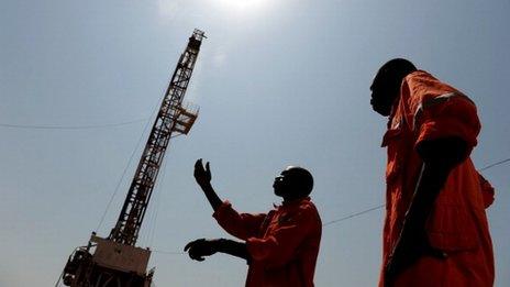 Two workers born in the oil reach Southern Sudan state of Unity, stand on the drilling site number 102 in the Unity oil field in Southern Sudan on November 11, 2010.