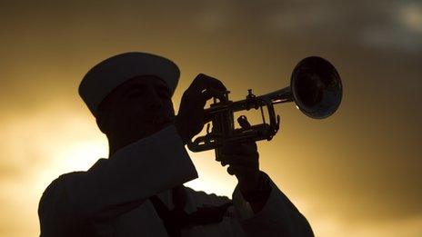 A US Navy sailor plays taps on Ford Island in Honolulu, Hawaii, on 6 December 2011