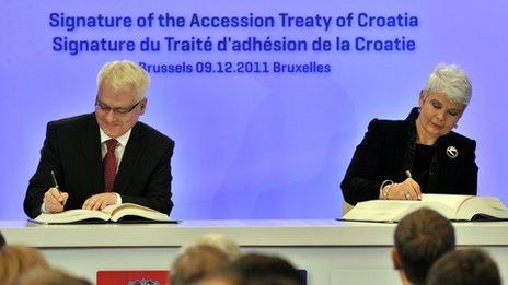 Croatian President Ivo Josipovic (left) and Prime Minister Jadranka Kosor sign their country's accession treaty in Brussels, 9 December