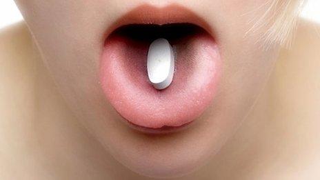 Pill on woman's tongue