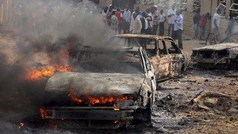 A car burns at the scene of a bombing at St Theresa Catholic Church near Abuja, 25 December 2011