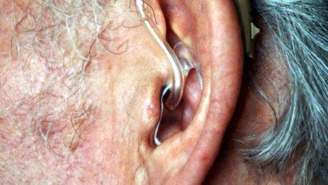 An elderly person wearing a hearing aid