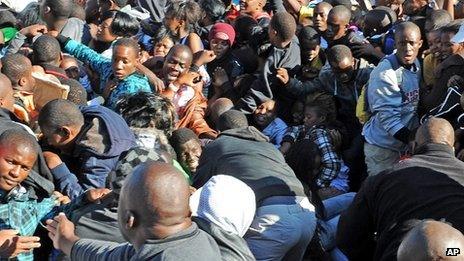 Thousands of young students and their parents push their way into the gates causing a stampede at the University of Johannesburg, South Africa, Tuesday 10 January 2012