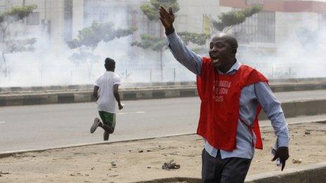Protesters run away from tear gas fired by police officers during a demonstration against spiralling fuel prices in Lagos, Nigeria, Monday, Jan. 16, 2012.