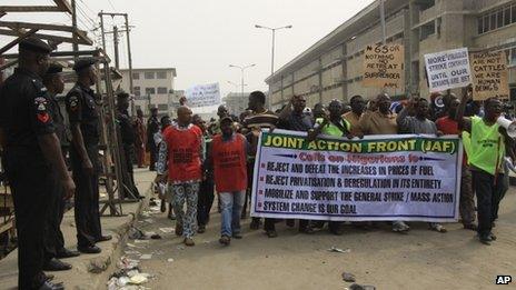 Policemen stand guard as angry youths protest on a street in Lagos, Nigeria, Monday, 16 January, 2012.