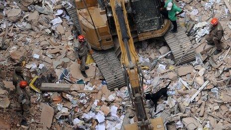 Rescue teams and a sniffer dog search the rubble in Rio de Janeiro