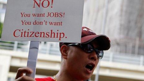 A protestor holds up a placard during a rally in Hong Kong against a bid by a Filipino domestic worker seeking permanent residency