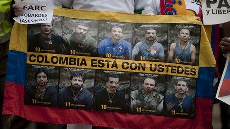 A man holds a banner with pictures of the ten Colombian police and military officers still held captive as hostages of the Farc in a demonstration in December 2011