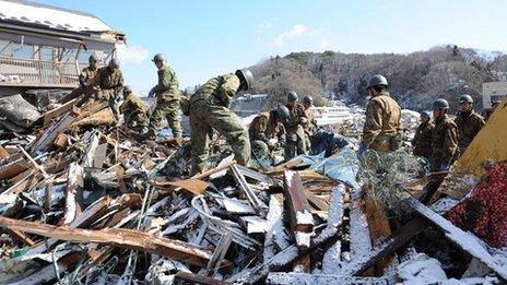 Military personnel search for survivors