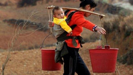 Woman carrying water from a well in Yiliang, southwest China