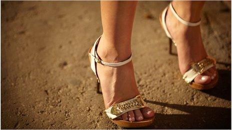 The feet of a woman wearing high heels