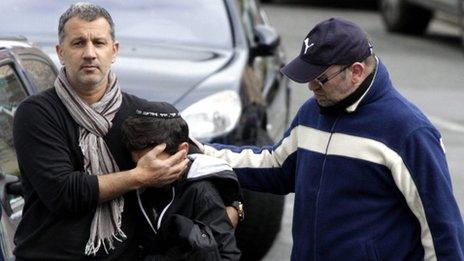 Man comforts pupil as they leave the Ozar Hatorah School, Toulouse (19 March)