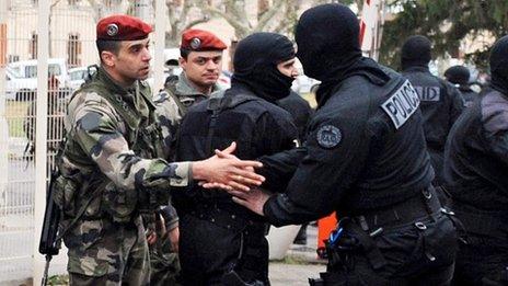 A masked member of France's RAID police commandos shakes hands with a paratrooper at Perignon barracks after the end of the siege in Toulouse, 22 March