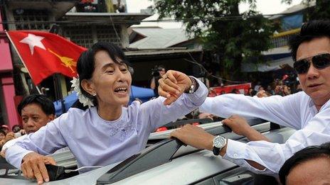 Aung San Suu Kyi waves to the crowd as she leaves her National League for Democracy headquarters in Yangon on April 2, 2012