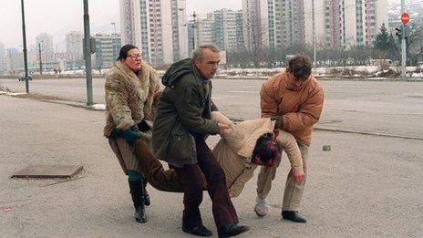 Sarajevo residents carry man wounded by Serb shelling, 8 Mar 93