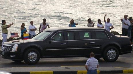 Locals wave as US President Barack Obama"s caravan drives by Cartagena"s Old Fortresss on April 13, 2012
