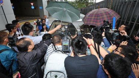 Reporters and photographers crowd a vehicle carrying Chairman of Sun Hung Kai Properties Thomas Kwok